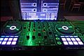 Pioneer DDJ-RX DJ-Controller (front) with computer running mixing software Rekordbox