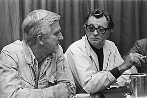 Archivo:Robert Mitchum (rechts) en Leslie Nielsen geven persconferentie in Amsterdam Hil, Bestanddeelnr 928-8120
