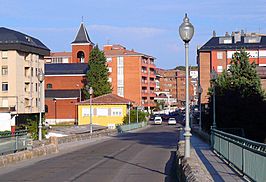 Acceso a la localidad la Avenida de Castilla y León y el puente sobre el río Carrión