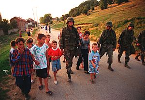 Archivo:990628-M-5696S-025 - U.S. Marines march with local children down street of Zegra, Kosovo