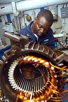 Archivo:US Navy 040902-N-7683J-003 Electrician's Mate 3rd Class Tayo Gbadebo from Lagos, Nigeria, rewires the motor from an Aqueous Film Forming Foam (AFFF) Sprinkler System's pump