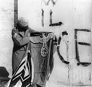Archivo:Sikh soldier with captured Swastika flag
