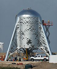 Fotografía de una etapa corta de un cohete de acero con sus aletas tocando el suelo