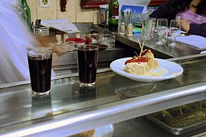 Dos vasos de vino y un aperitivo en la barra de un bar madrileño.