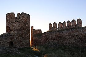 Torreón circular y muralla almenada.