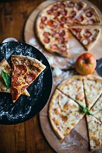 Archivo:Two different slices of pizza at a restaurant closeup. (49134666467)
