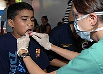 Archivo:US Navy 090628-N-6259S-001 Capt. Amber Heller examines a Salvadoran child's teeth during a Continuing Promise 2009 medical community service project in Loma Larga, El Salvador