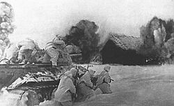 Archivo:Soviet T-34 with desant rushing into village