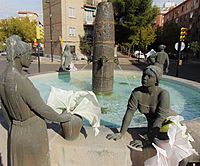 escultura de 2 mujeres, una en pie y otra sentada al lado de una fuente