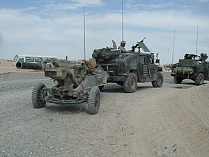 Archivo:M1114 towing M102 Howitzer