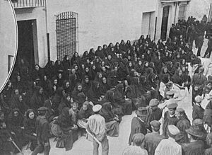 Archivo:1912-06-10, La Ilustración Artística, La catástrofe de Villarreal (cropped) Vecinas de Villarreal rezando delante de la casa en donde se hallaba expuesto el cadáver de una de las víctimas