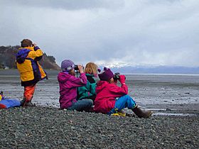 Archivo:Children sit on the beach and watching the horizon with binoculars