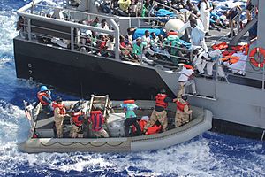 Archivo:Distressed persons are transferred to a Maltese patrol vessel.