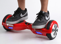 Red self-balancing two-wheeled board with a person standing on it