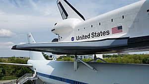 The Shuttle Independence sits atop the Shuttle Carrier Aircraft with the Johnson Space Center and Rocket Park in the background