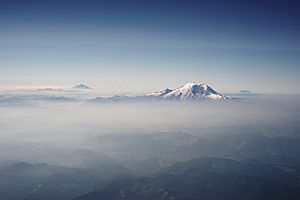 Mount Rainier and other Cascades mountains poking through clouds.jpg