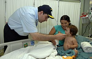 Archivo:US Navy 070727-N-0194K-052 President of El Salvador, Elias Saca, shares a moment with a young child and her mother aboard the Military Sealift Command hospital ship USNS Comfort (T-AH 20)