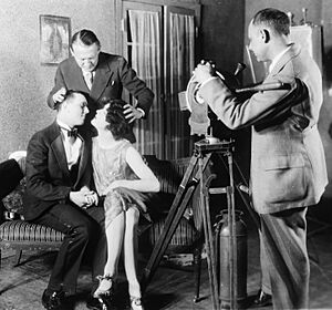 Edmund Goulding helping two actors kiss 1927.jpg